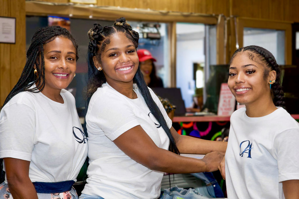 Three community members smiling at the bowling event.
