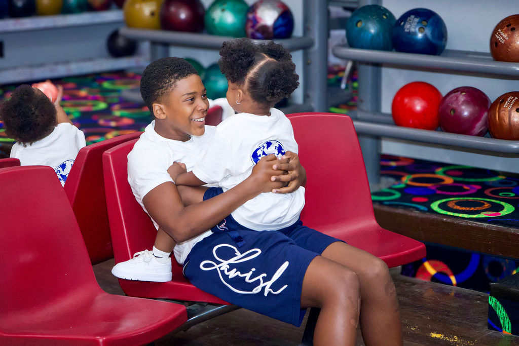 Two children sharing a joyful moment at the bowling event.